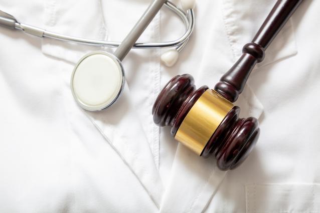 personal injury medical malpractice gavel and doctor listening tool on labcoat